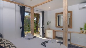 A bedroom with a large bed, a wooden desk, a mirror, and a view of the outdoors. - Oltavista 10 pax - Benissa, Costa Blanca (Benissa)