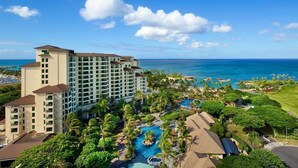 A resort with multiple buildings, a large swimming pool, and a view of the ocean. - Ko Olina | Beach & Pool Access | Tropical Resort Stay (Kapolei)