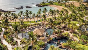 An aerial view of a resort with a beach, palm trees, and a pool area. - Ko Olina | Beach & Pool Access | Tropical Resort Stay (Kapolei)