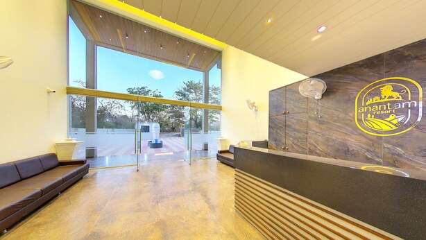 Un área de recepción con mostrador de mármol, un logotipo en la pared y vistas al exterior.