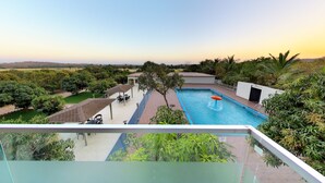 Una piscina en la azotea con vistas despejadas del paisaje circundante, incluyendo árboles y colinas a la distancia.