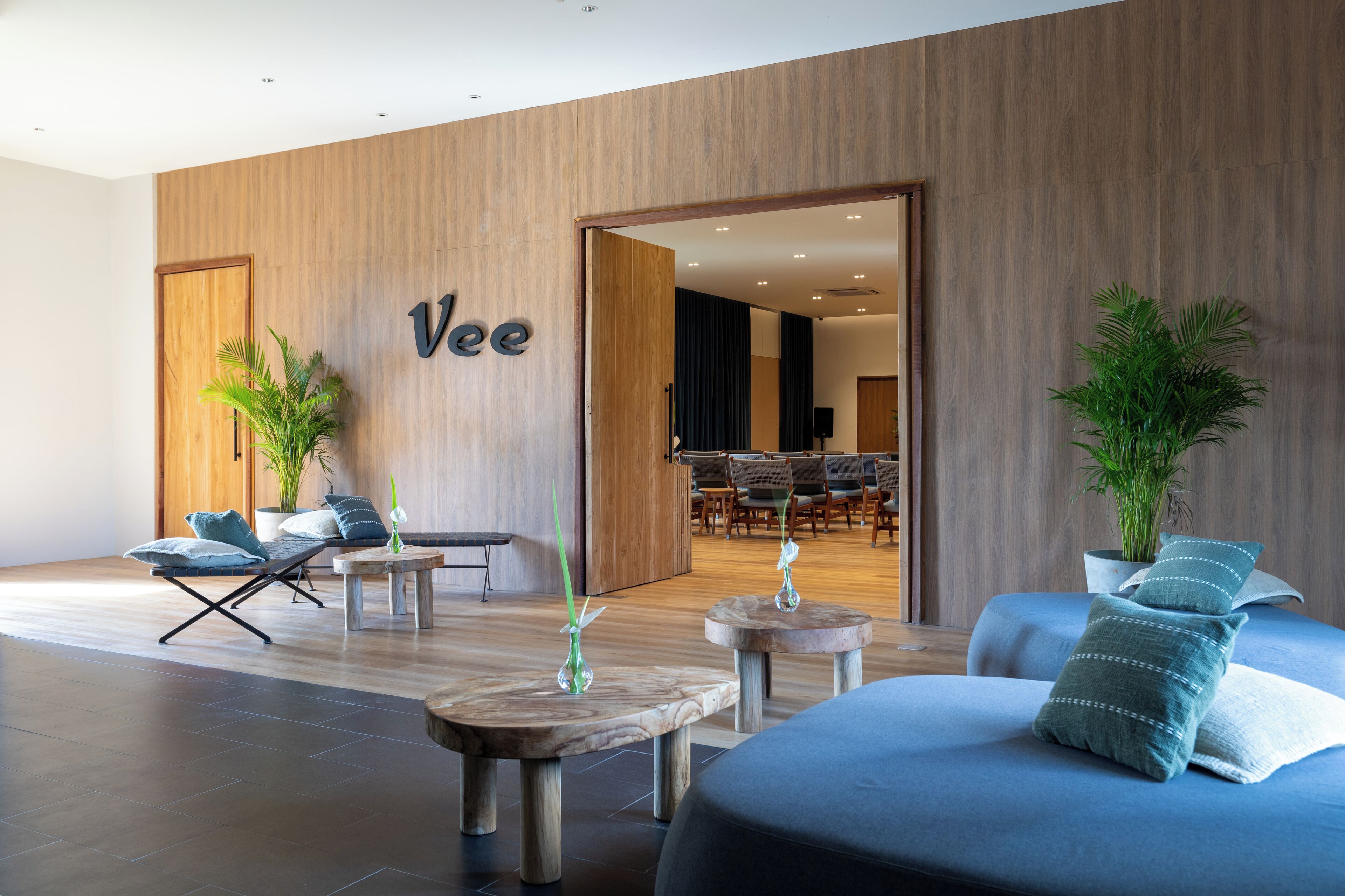 Un moderno vestíbulo de hotel con una pared de madera, un mostrador de recepción y una zona de estar.