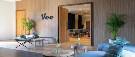 Un moderno vestíbulo de hotel con una pared de madera, un mostrador de recepción y una zona de estar.