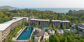 Een resort met meerdere gebouwen, een zwembad en uitzicht op de oceaan.