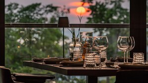 A table set for dining with a view of the sunset through a window. - Varana Hotel Krabi (Krabi)