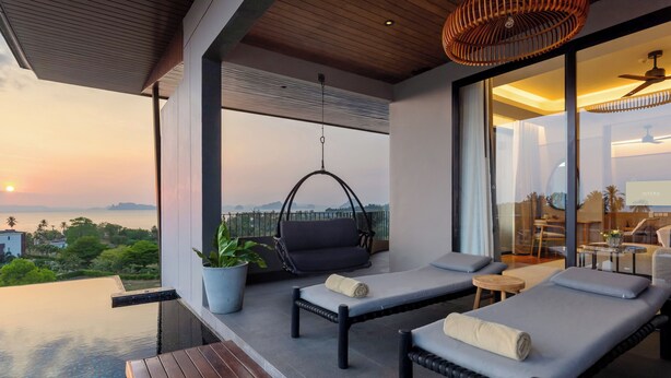 A modern balcony with two lounge chairs, a hanging chair, and a wooden table. - Varana Hotel Krabi (Krabi)