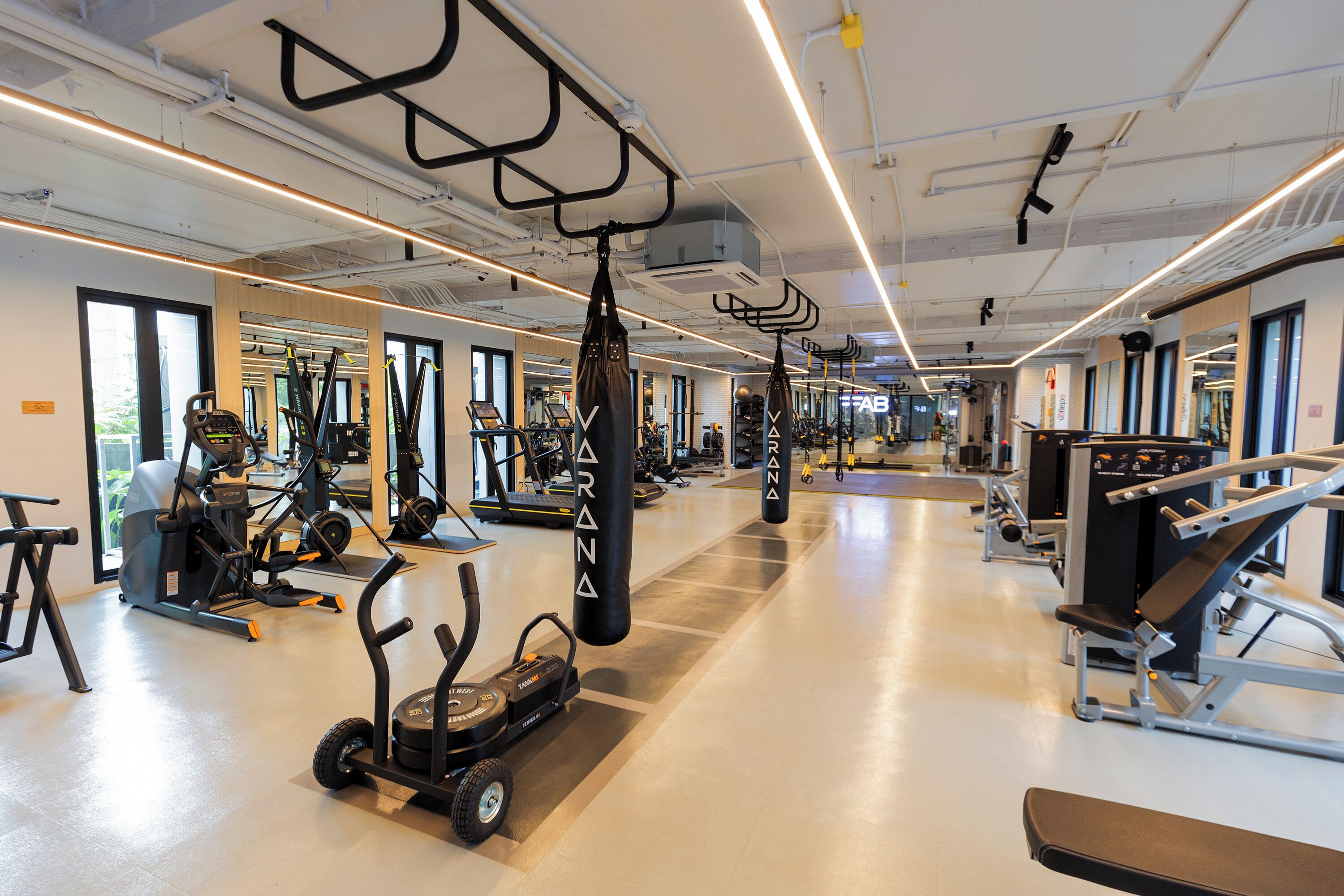 A gym with various exercise equipment, including treadmills, stationary bikes, and weight machines.