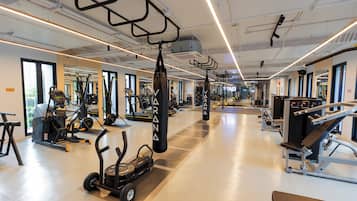 A gym with various exercise equipment, including treadmills, stationary bikes, and weight machines.