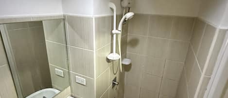 A bathroom with a sink, mirror, and shower.