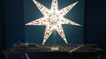 Un adorno con forma de estrella sobre una mesa de mármol frente a una pared azul oscuro.