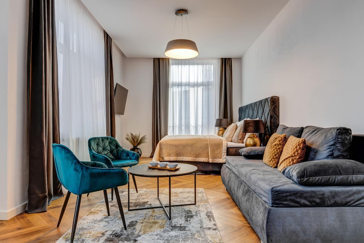 A modern living room with a sofa, a chair, a coffee table, and a bed.