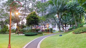 Un camí sinuós a un parc, amb bancs, arbres i una zona de jocs.