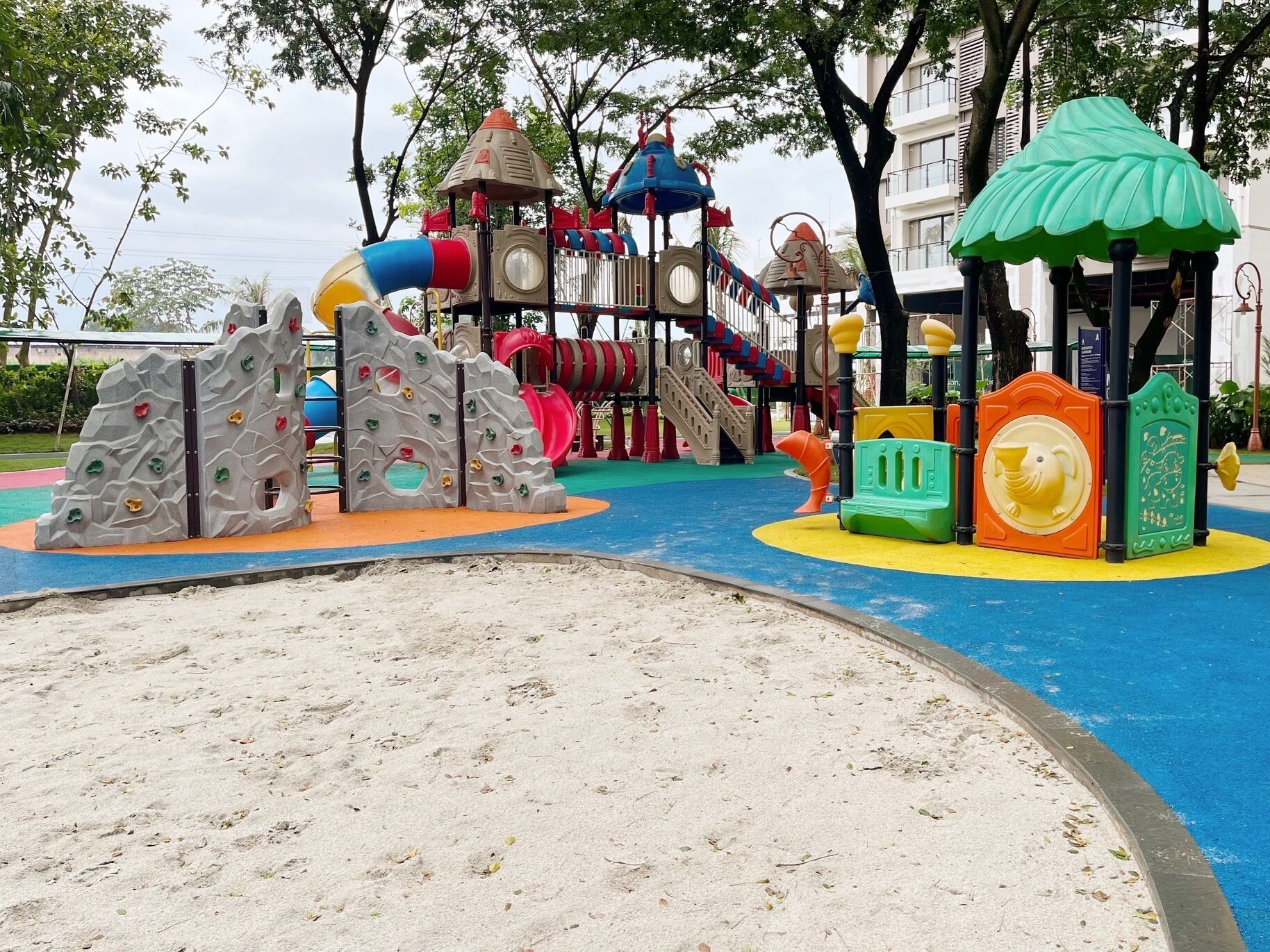 A playground with climbing structures, slides, and a playhouse.