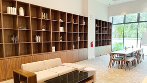 Una biblioteca moderna amb un sofà, una taula de cafè i prestatges de llibres.