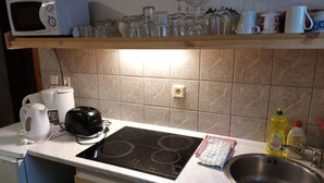 Une cuisine équipée d’un four à micro-ondes, d’un grille-pain, d’une bouilloire et d’un évier.