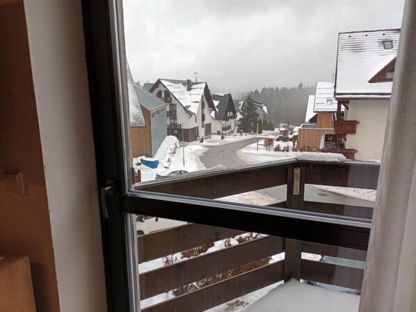 A view from a window of a residential area with houses and a road covered in snow. - Mountain Duplex & Balcony by Interhome (Harrachov)