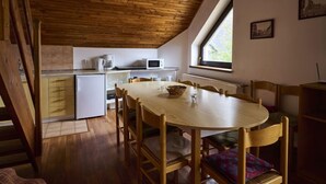 Een gezellige keuken met houten balken, een eettafel en stoelen.