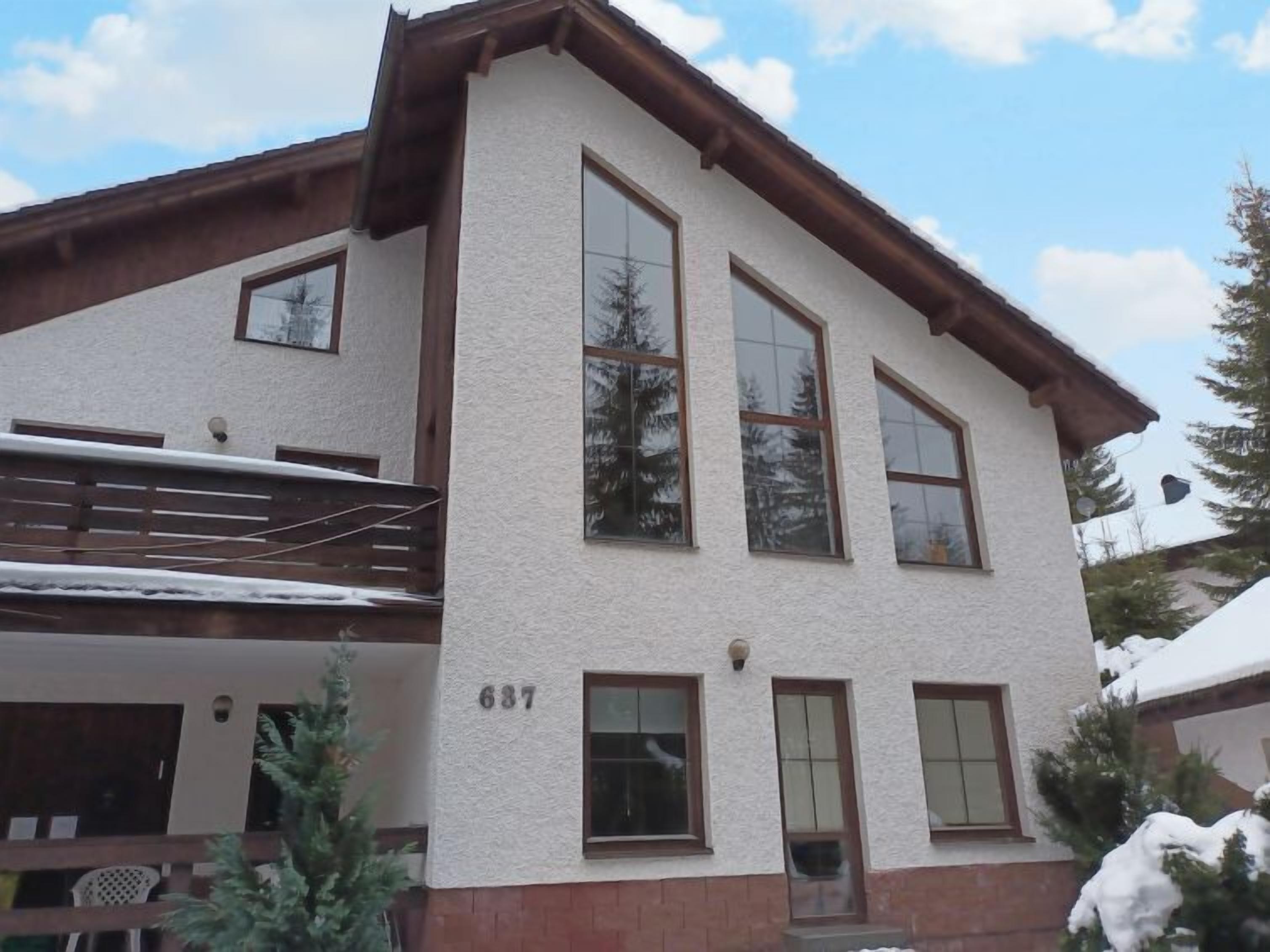 A two-story building with a white exterior and brown trim. The number 687 is visible on the front wall.