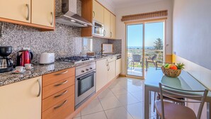 A modern kitchen with granite countertops, stainless steel appliances, and a view to the outside. - Vista Mar by Interhome (Albufeira)