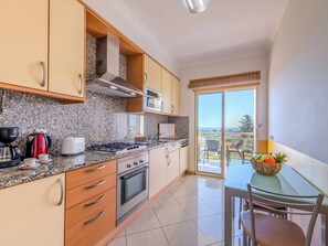 Una cocina moderna con encimeras de granito, electrodomésticos de acero inoxidable y vistas al exterior.