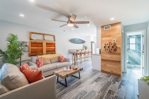 Un salon moderne avec un canapé, une table basse et un mur décoratif en bois.