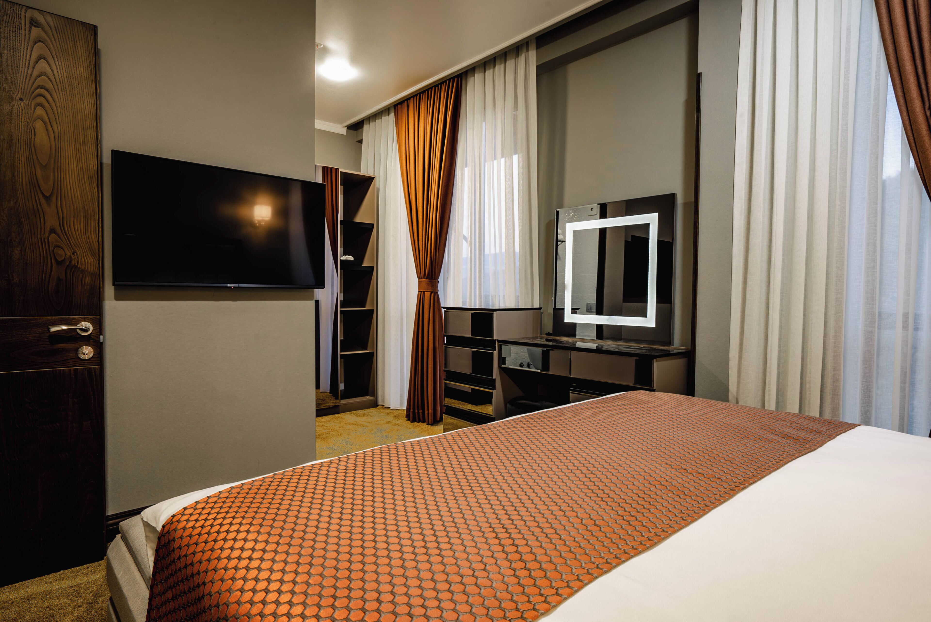 Une chambre d’hôtel équipée d’un lit, d’une télévision, d’un bureau et d’une armoire.