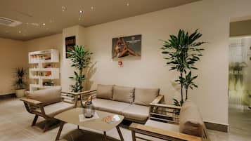A modern reception area with a sofa, chairs, a coffee table, and a bookshelf.