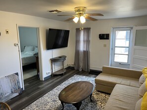 A living room with a ceiling fan, a flat-screen TV, a sofa, a coffee table, and a patterned rug. - Comfy Quiet 1bedroom apartment, close to DT Winslow (Winslow)