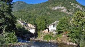 Ein Fluss, der durch ein Tal fließt, mit Häusern am Ufer.