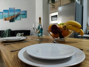 A dining table with a fruit bowl, wine glass, and plates. - Renovated apartment in central Torremolinos with Wi-Fi and air conditioning (Torremolinos)