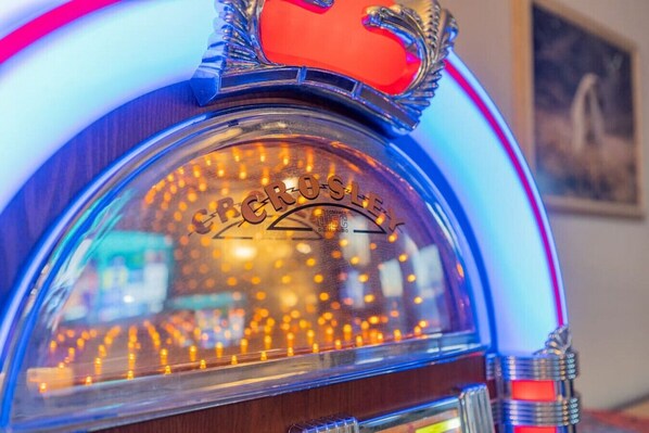 A jukebox with a clear glass front and the brand name 'SPROULLEY' visible on the top.