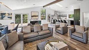 Ein geräumiges Wohnzimmer mit einer Sofagarnitur, einem Couchtisch und einem Essbereich mit Tisch und Stühlen.
