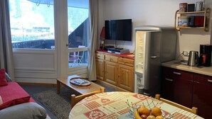 A compact living space with a dining area, kitchenette, and a television. - Superb 32 m2 apartment with GARAGE and slope view (VARS)
