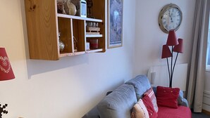 A cozy room with a grey sofa, a wooden dresser, and a red lamp. - Superb 32 m2 apartment with GARAGE and slope view (VARS)