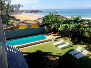 A swimming pool with lounge chairs, a view of the beach, and a tropical setting. - Beach Villa Yang near Hikkaduwa, with Pool and Cook - Semi-detached House (Hikkaduwa)