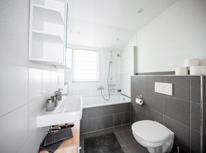 Un bagno moderno con vasca, water e doccia.