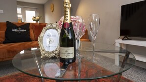 A glass table with a bottle of Moët & Chandon Brut champagne, a framed certificate, and two empty wine glasses. - Champagne House - 3 Bedroom Townhouse (Darlington)