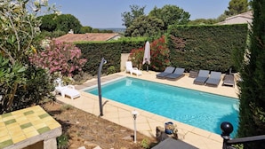 Une piscine dotée de chaises longues et offrant une vue sur le paysage environnant.