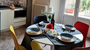 A modern kitchen with a dining area set for four. - Apartment with terrace, parking A/C, Wi-Fi, in the old town (Pistoia)