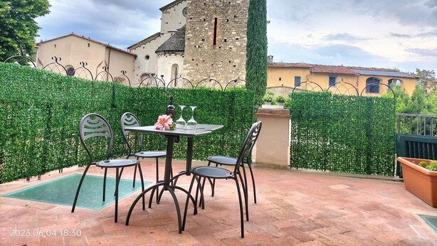 An outdoor patio with a table and chairs, a small pool, and a stone tower in the background. - Apartment with terrace, parking A/C, Wi-Fi, in the old town (Pistoia)