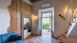 A modern kitchen with a built-in oven and a dining area with a table and chairs. - Apartment with terrace, parking A/C, Wi-Fi, in the old town (Pistoia)
