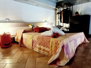 A bedroom with a bed, pillows, a nightstand, a dresser, and a mirror.