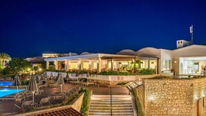 A hotel with a pool area, outdoor seating, and a staircase leading to the upper levels. - Annabelle Beach Resort (Hersonnisos, Crete)
