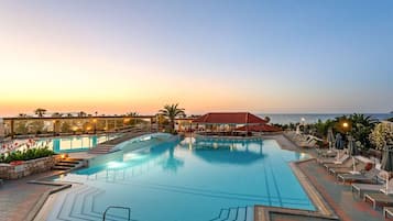 Alberca techada, alberca al aire libre y camastros