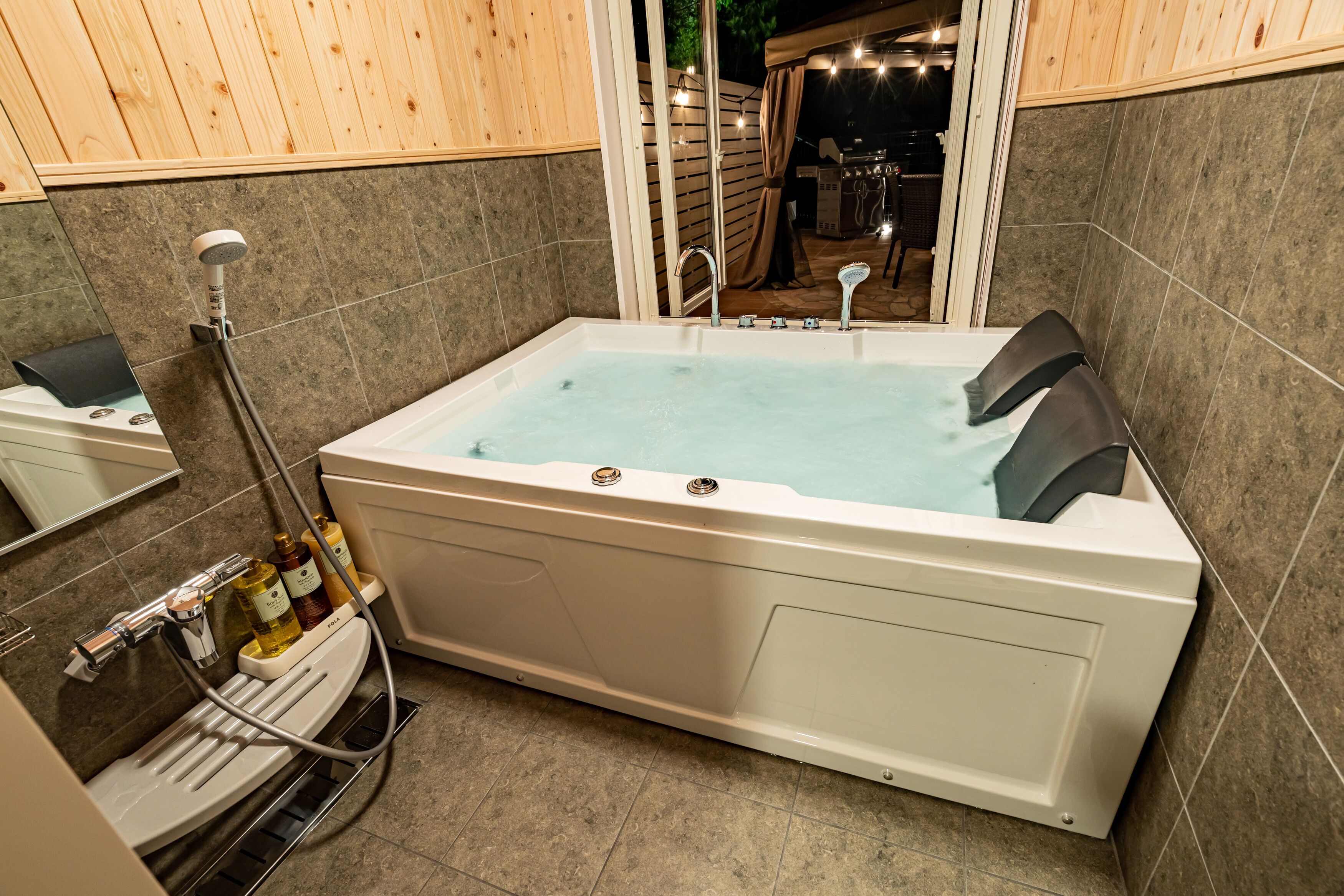 A modern bathroom with a large bathtub, a shower area, and a vanity with toiletries.