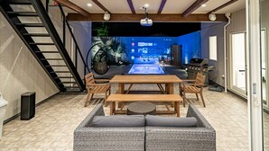 En moderne stue med et træbord, sofa og trappe.