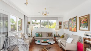 A spacious living room with a herringbone floor, a sofa set, a coffee table, and a chandelier. - That 70s House in Mount Waverley (Mount Waverley)