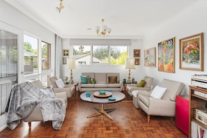 A spacious living room with a herringbone floor, a sofa set, a coffee table, and a chandelier. - That 70s House in Mount Waverley (Mount Waverley)