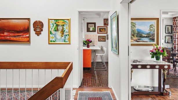 A hallway with a staircase, a dining area with a table and chairs, and various framed artworks on the walls. - That 70s House in Mount Waverley (Mount Waverley)