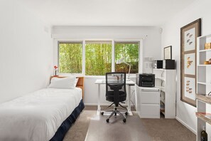 A bedroom with a bed, desk, chair, and a window with a view of greenery. - That 70s House in Mount Waverley (Mount Waverley)